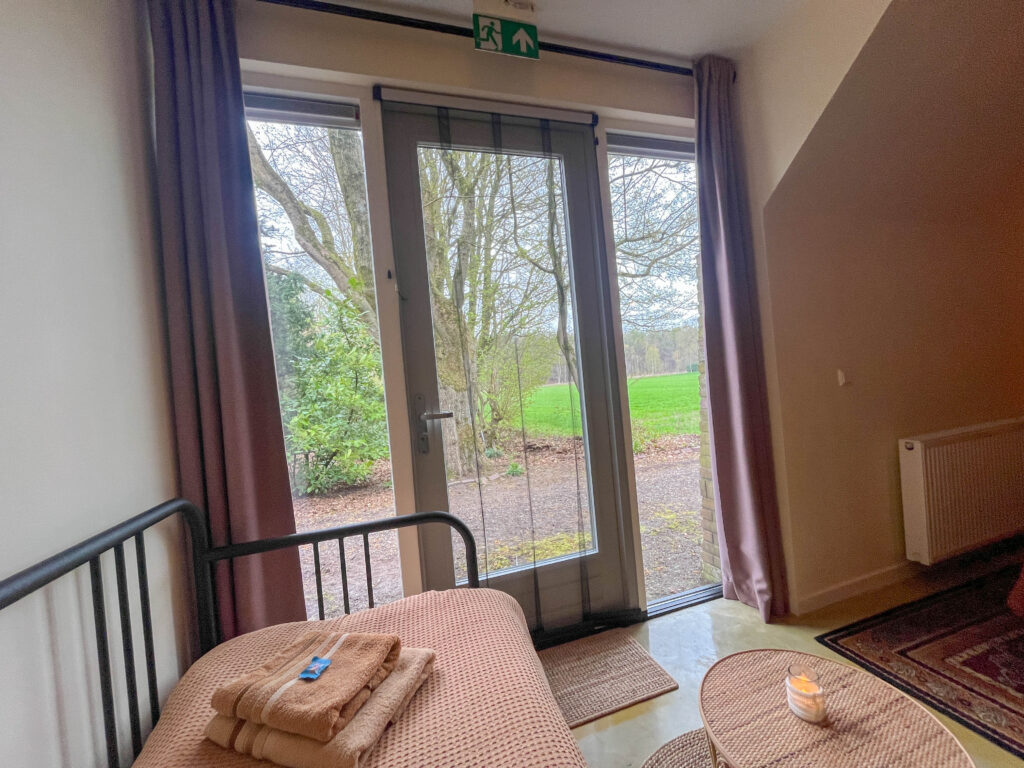 Kamer 3 met slaapbank en uitzicht op de tuin.